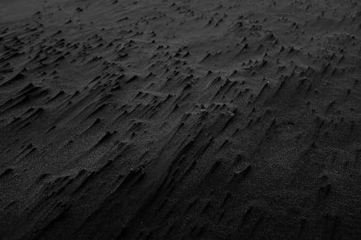 Abstract black sand texture creating a dramatic and moody background.
